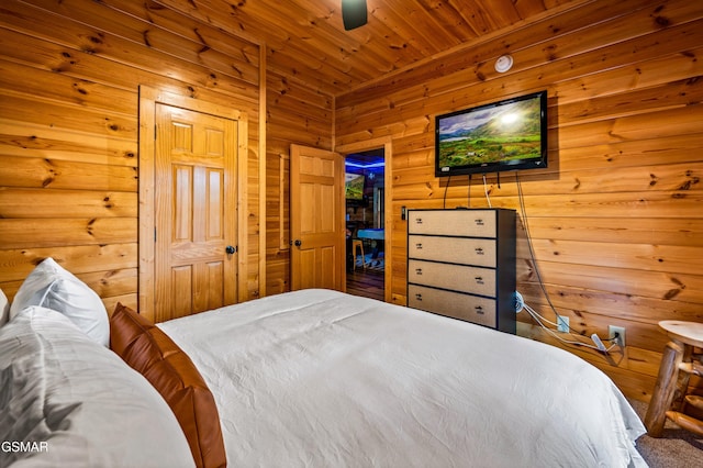 bedroom featuring wood walls, wooden ceiling, and a ceiling fan