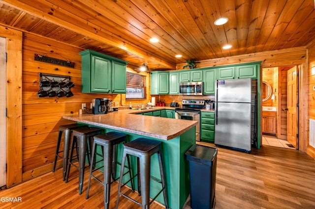 kitchen with a peninsula, wood ceiling, light wood-style floors, appliances with stainless steel finishes, and green cabinets