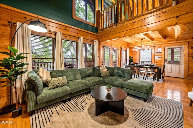 living area with wood-type flooring, wooden walls, and a chandelier