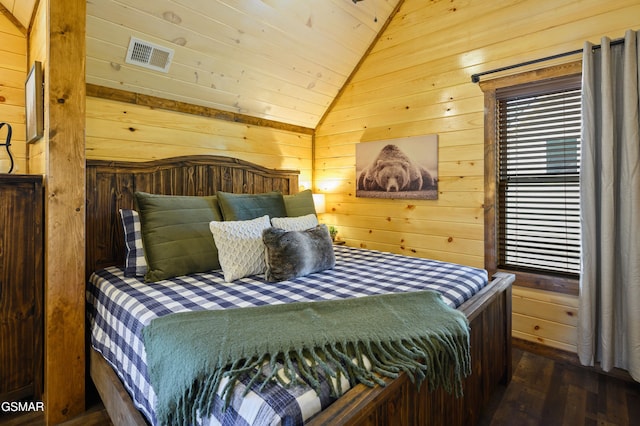 bedroom with dark wood-type flooring, lofted ceiling, wooden walls, and multiple windows