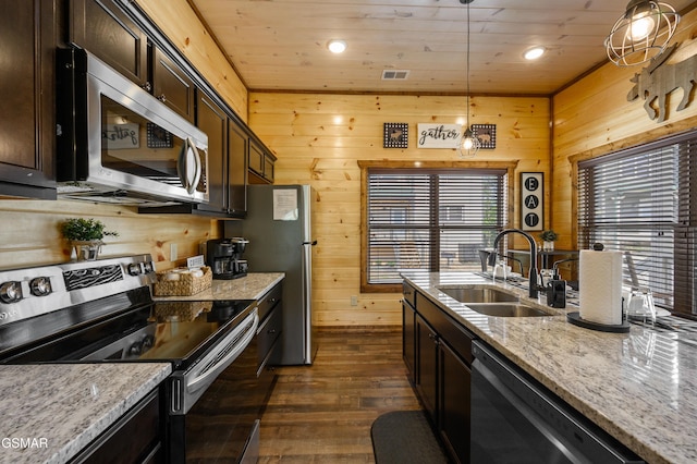 kitchen featuring sink, hanging light fixtures, dark brown cabinetry, light stone counters, and stainless steel appliances