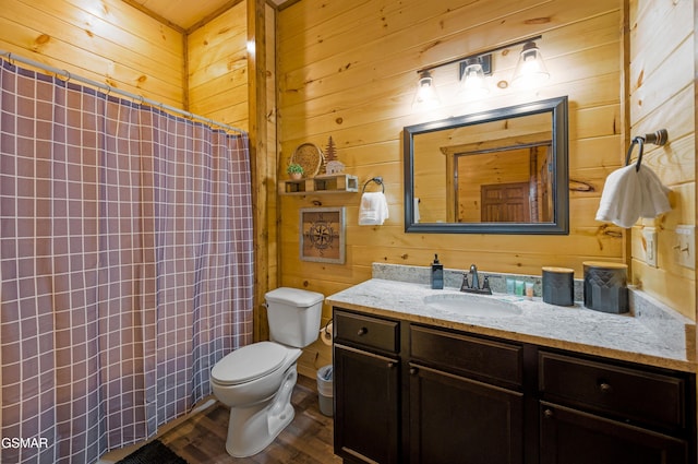 bathroom with wood-type flooring, toilet, vanity, and wood walls