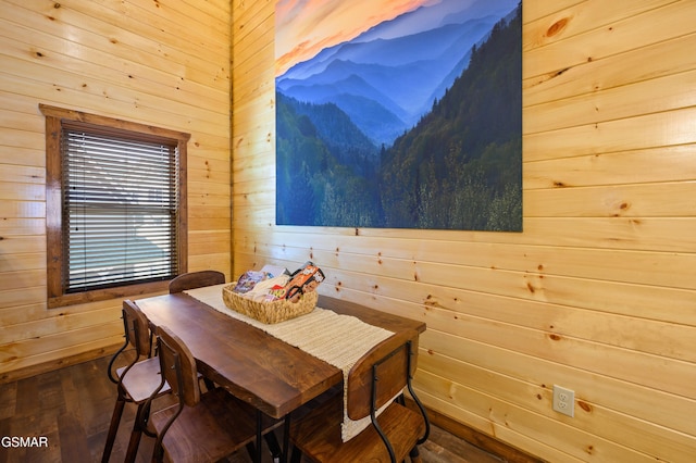 dining area featuring dark hardwood / wood-style flooring and wooden walls