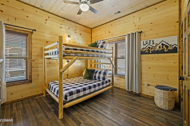 bedroom with wooden ceiling, dark hardwood / wood-style floors, and wood walls