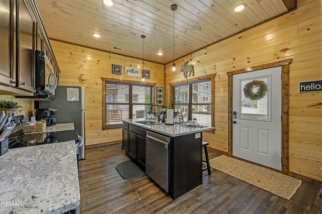 kitchen featuring sink, a center island with sink, pendant lighting, stainless steel appliances, and light stone countertops