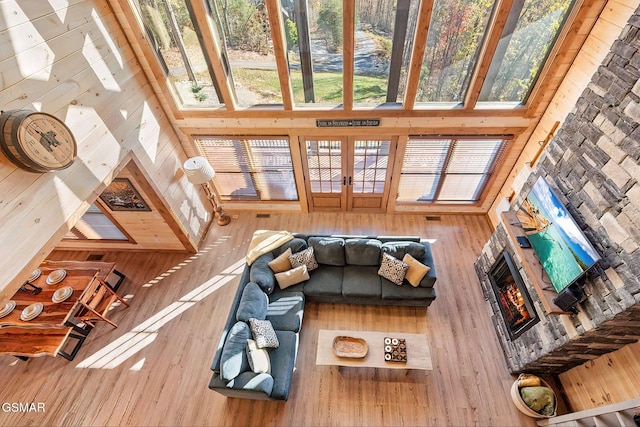 2229 Legend Dr, Sevierville, TN 37876 - living area with a high ceiling, a lit fireplace, wooden walls, and wood finished floors