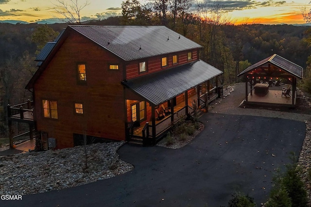 2229 Legend Dr, Sevierville, TN 37876 - back of house at dusk featuring covered porch, a carport, driveway, and a metal roof