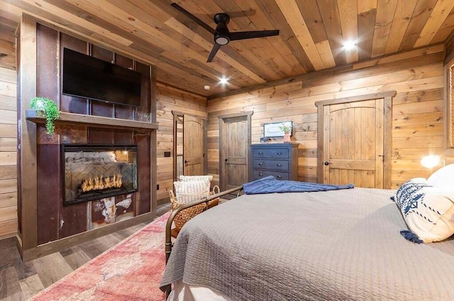 bedroom with wood walls, ceiling fan, wooden ceiling, and hardwood / wood-style flooring