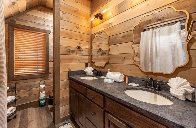 bathroom featuring wood walls, hardwood / wood-style floors, vanity, and walk in shower