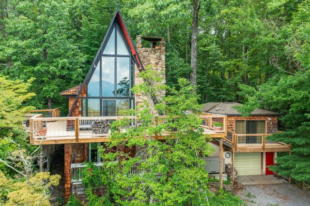 back of property with a garage and a wooden deck