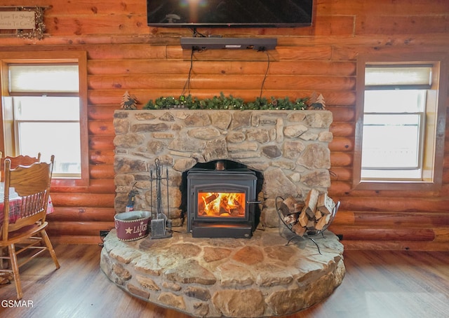 interior details with a wood stove and wood finished floors