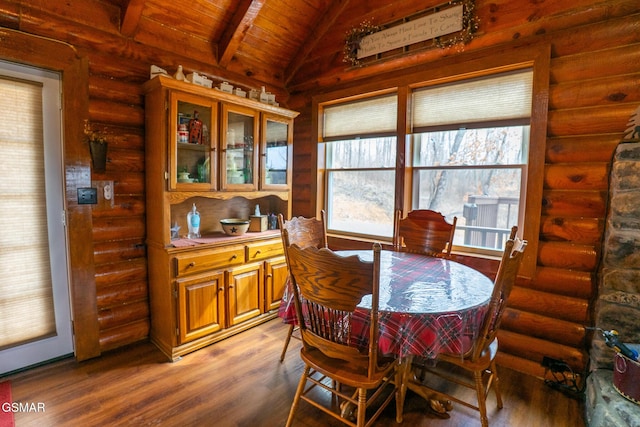 dining area with lofted ceiling with beams, rustic walls, wood finished floors, and wooden ceiling