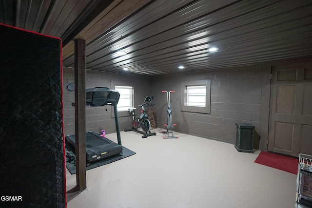 exercise room featuring a healthy amount of sunlight and concrete block wall