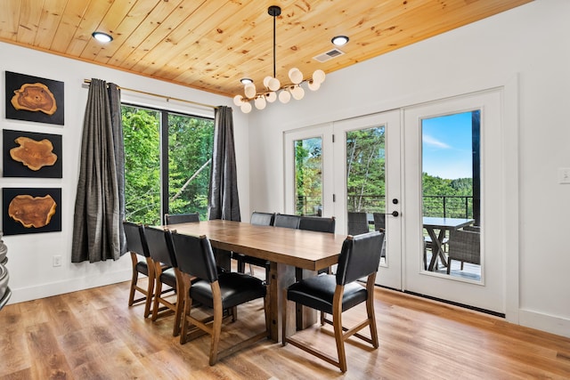 dining space with french doors, a notable chandelier, wood ceiling, and light hardwood / wood-style floors