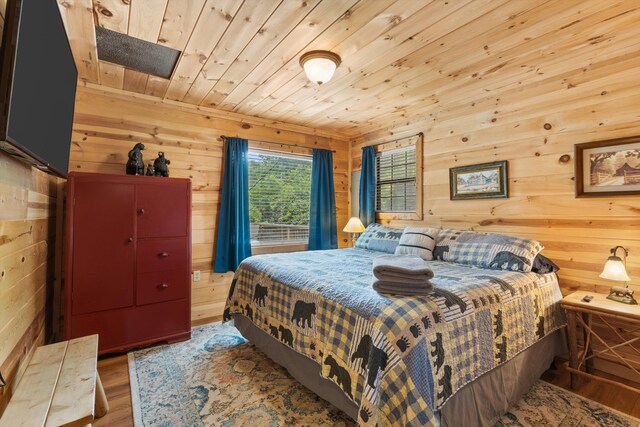 bedroom with wood-type flooring, wooden walls, and wooden ceiling