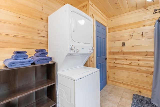 washroom featuring wooden walls, stacked washing maching and dryer, and wooden ceiling