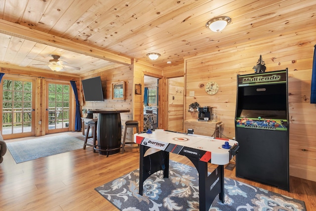 game room with beam ceiling, ceiling fan, wooden walls, and wooden ceiling