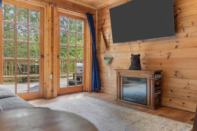 doorway with light hardwood / wood-style flooring and wooden walls