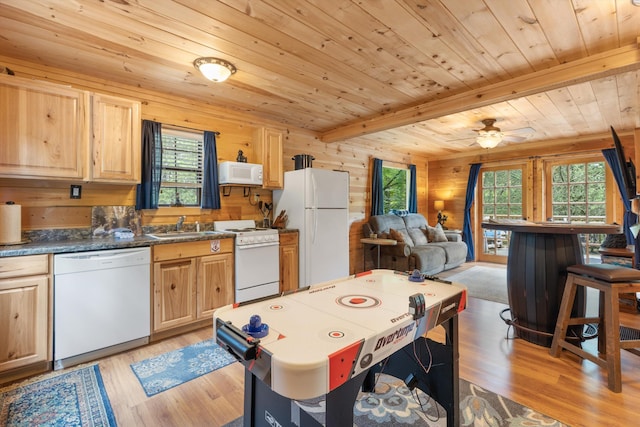 kitchen featuring beamed ceiling, white appliances, a healthy amount of sunlight, and wood ceiling