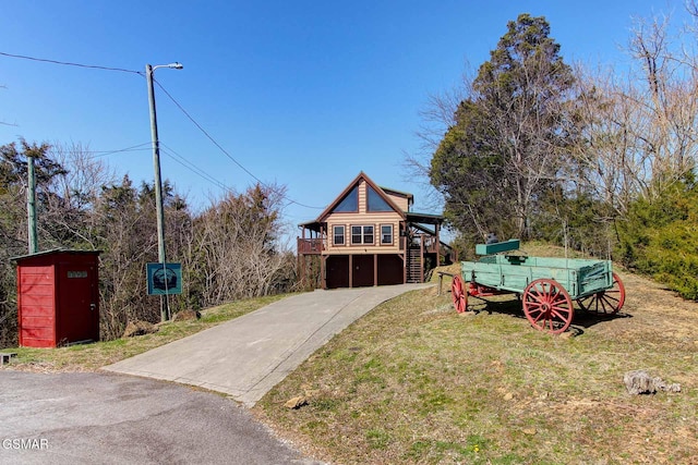 view of front of home with a front lawn, stairway, an attached garage, and driveway