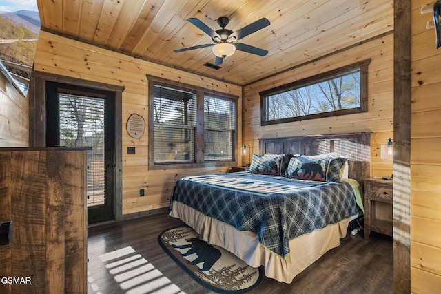 bedroom with wood walls, wooden ceiling, wood finished floors, and visible vents