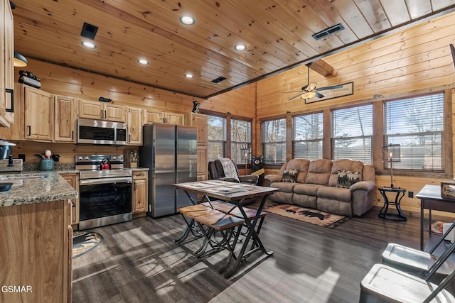 kitchen featuring wooden ceiling, stainless steel appliances, wood walls, visible vents, and light brown cabinetry