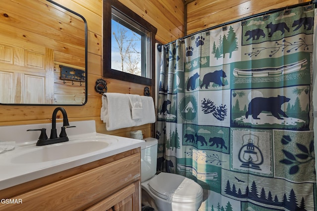 full bath with toilet, curtained shower, wooden walls, and vanity