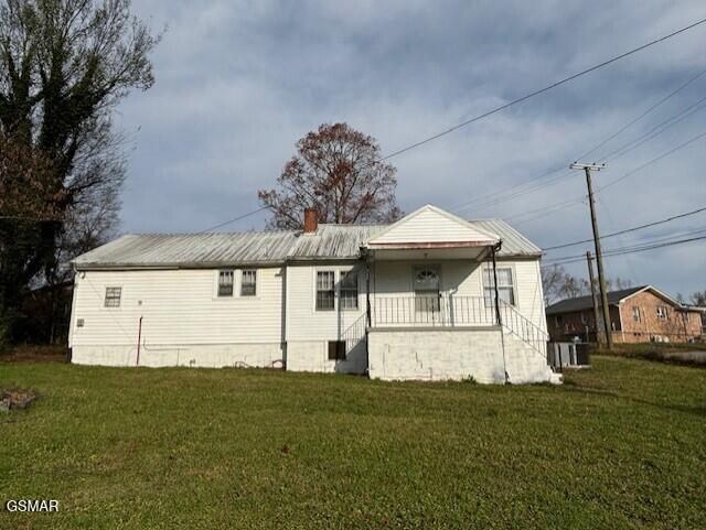 back of property featuring a porch and a lawn