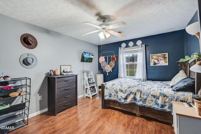 bedroom featuring hardwood / wood-style flooring, ceiling fan, and a textured ceiling