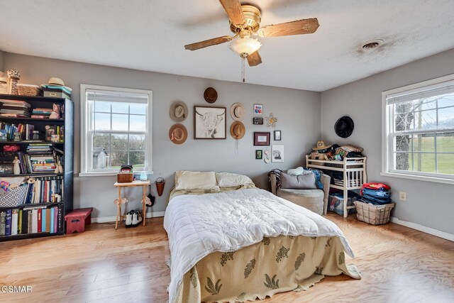 bedroom with ceiling fan and light hardwood / wood-style floors