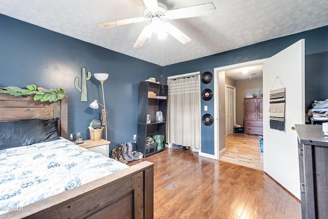 bedroom with hardwood / wood-style floors, a textured ceiling, and ceiling fan