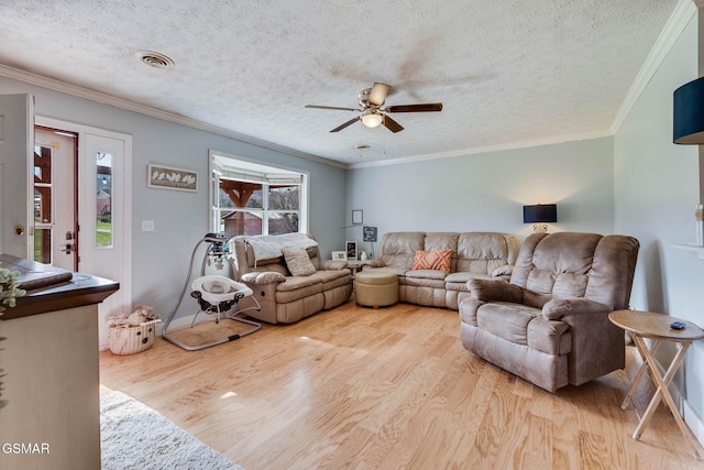 living room with ceiling fan, a textured ceiling, and ornamental molding