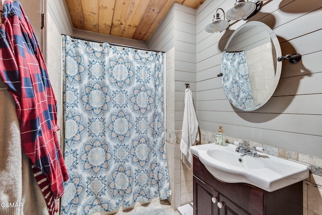 bathroom with wood walls, vanity, wooden ceiling, and walk in shower