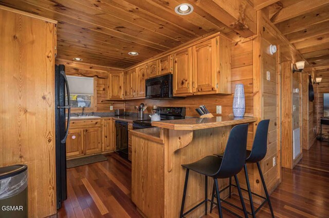 2412 Breezey Ridge Dr, Sevierville, TN 37876 - kitchen featuring black appliances, wooden ceiling, dark wood-style floors, a peninsula, and wooden walls