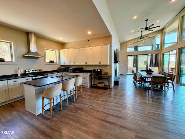 3343 Summit Trails Dr, Sevierville, TN 37862 - kitchen with wall chimney range hood, dark countertops, a wealth of natural light, and electric range