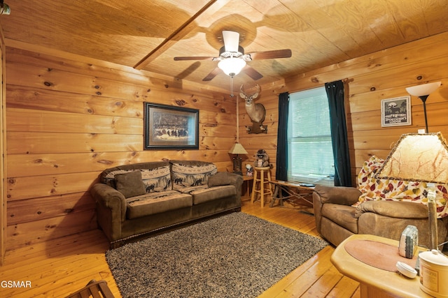 living room featuring wooden ceiling, hardwood / wood-style flooring, wooden walls, and a ceiling fan