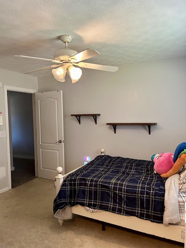 carpeted bedroom featuring ceiling fan and a textured ceiling