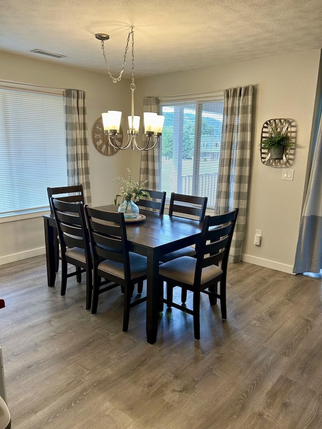 dining area featuring a chandelier, hardwood / wood-style flooring, and a healthy amount of sunlight