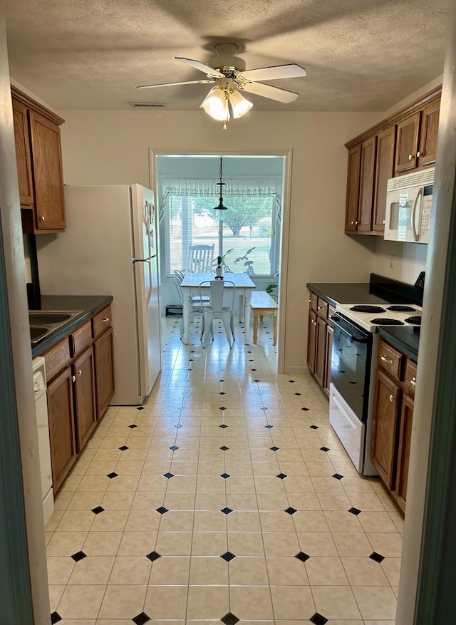 kitchen featuring ceiling fan, light tile patterned flooring, white appliances, and a textured ceiling