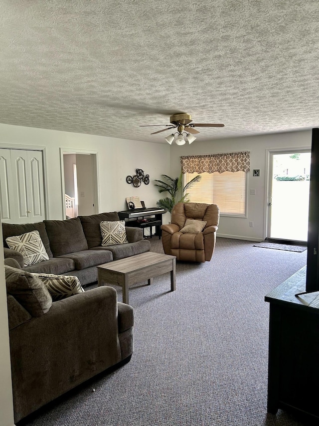 carpeted living room with ceiling fan and a textured ceiling