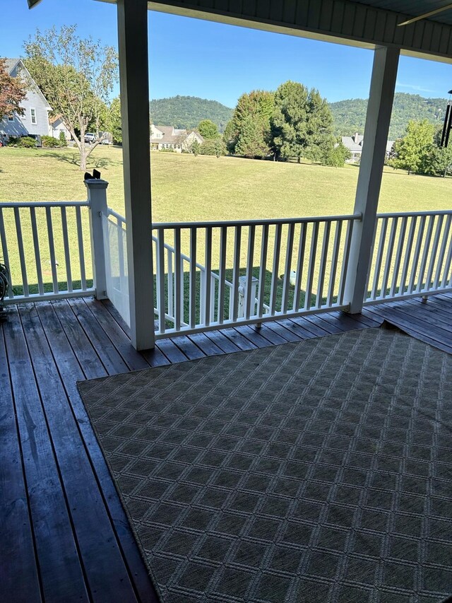 wooden terrace featuring a yard