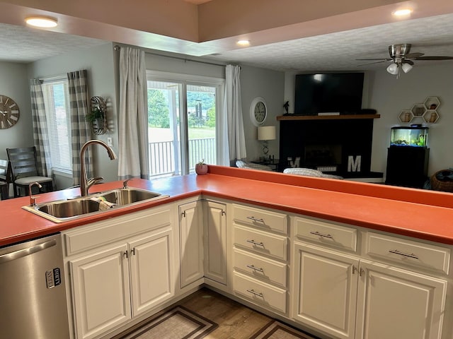 kitchen with ceiling fan, sink, stainless steel dishwasher, hardwood / wood-style floors, and white cabinets