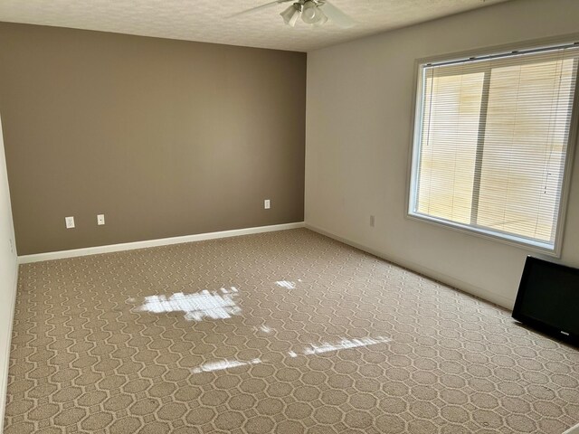 unfurnished room with ceiling fan, a textured ceiling, and a wealth of natural light