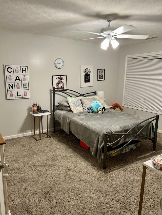 carpeted bedroom with a textured ceiling, baseboards, and ceiling fan
