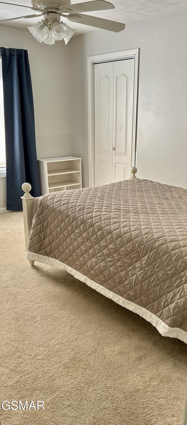 bedroom with carpet floors, ceiling fan, and a closet