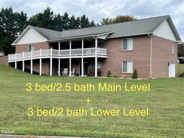 back of property with a yard and brick siding