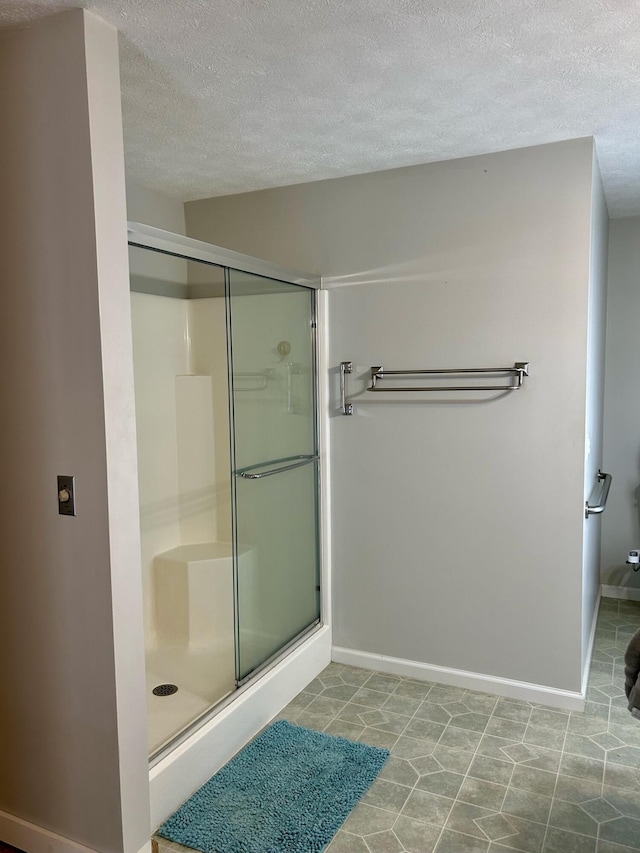 bathroom featuring a textured ceiling and an enclosed shower