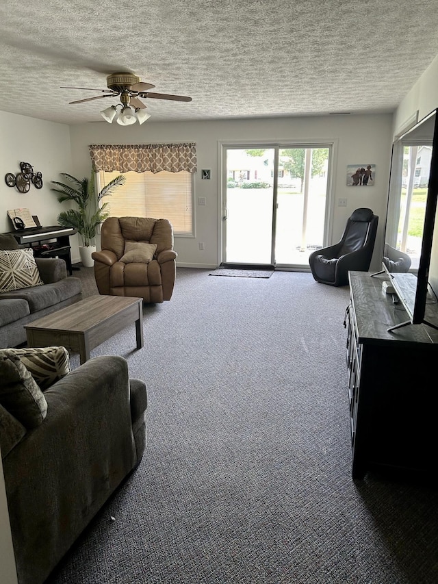 carpeted living area with a textured ceiling, plenty of natural light, and ceiling fan