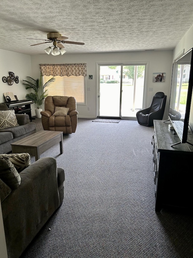 living room featuring carpet flooring, ceiling fan, and a textured ceiling