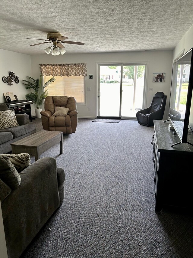 living room with ceiling fan, a textured ceiling, carpet floors, and a healthy amount of sunlight